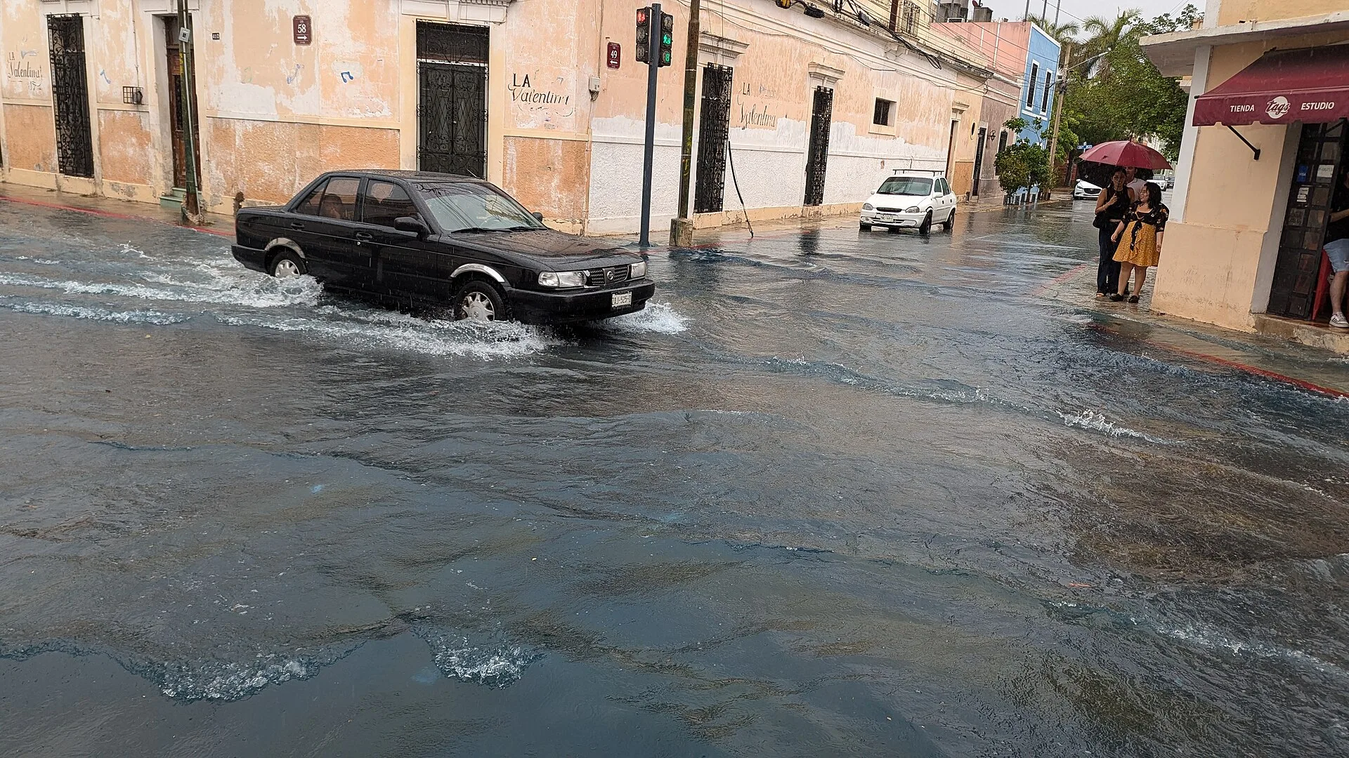 Carro atravessando rua alagada