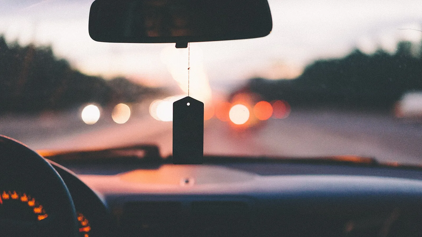 Volante e painel de carro em movimento numa rodovia