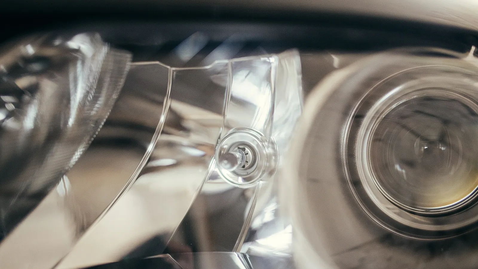 Detalhe interno de um farol automotivo com refletor, lente e projetor