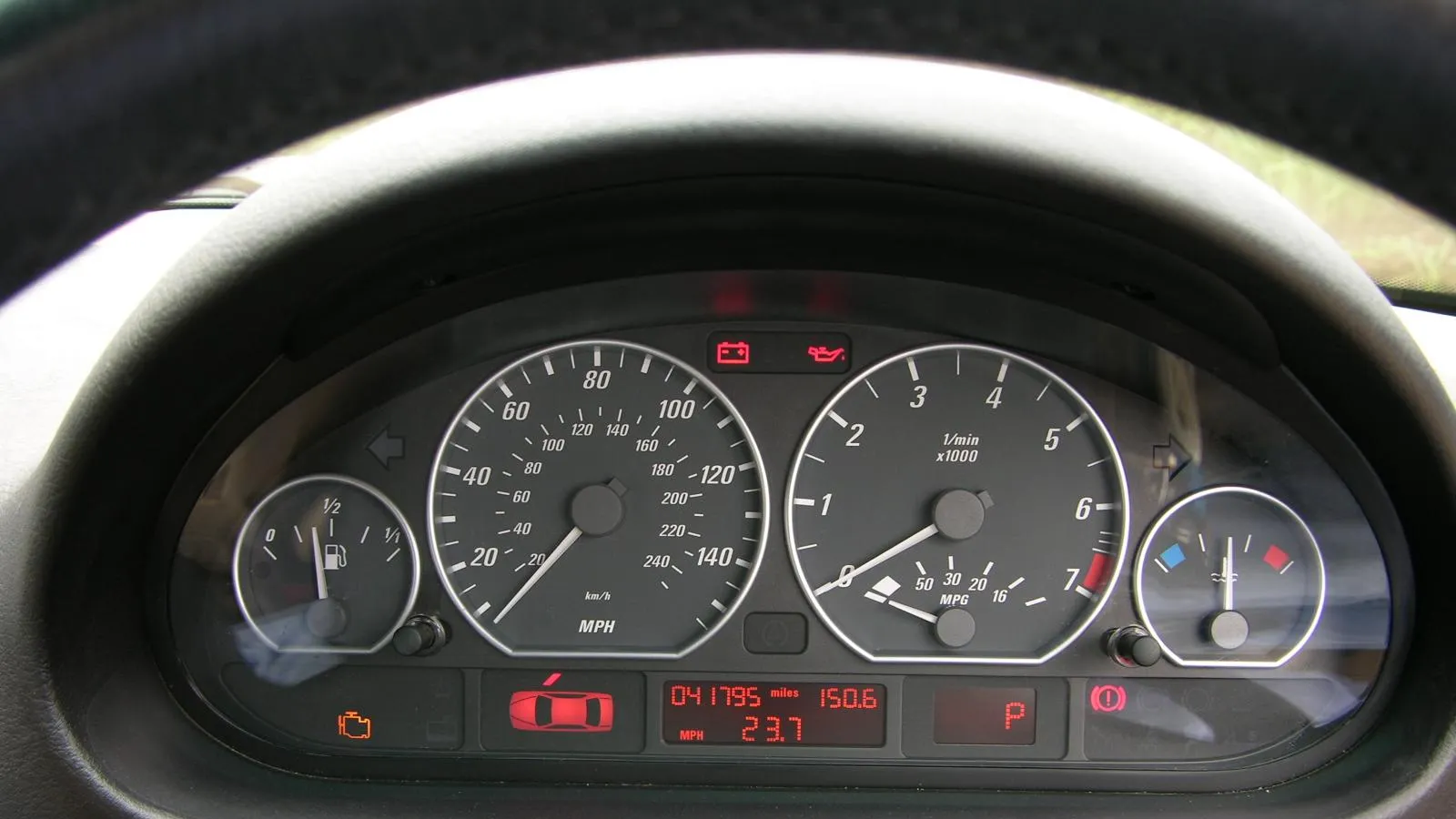 Painel de instrumentos de um carro com velocímetro e conta-giros iluminados